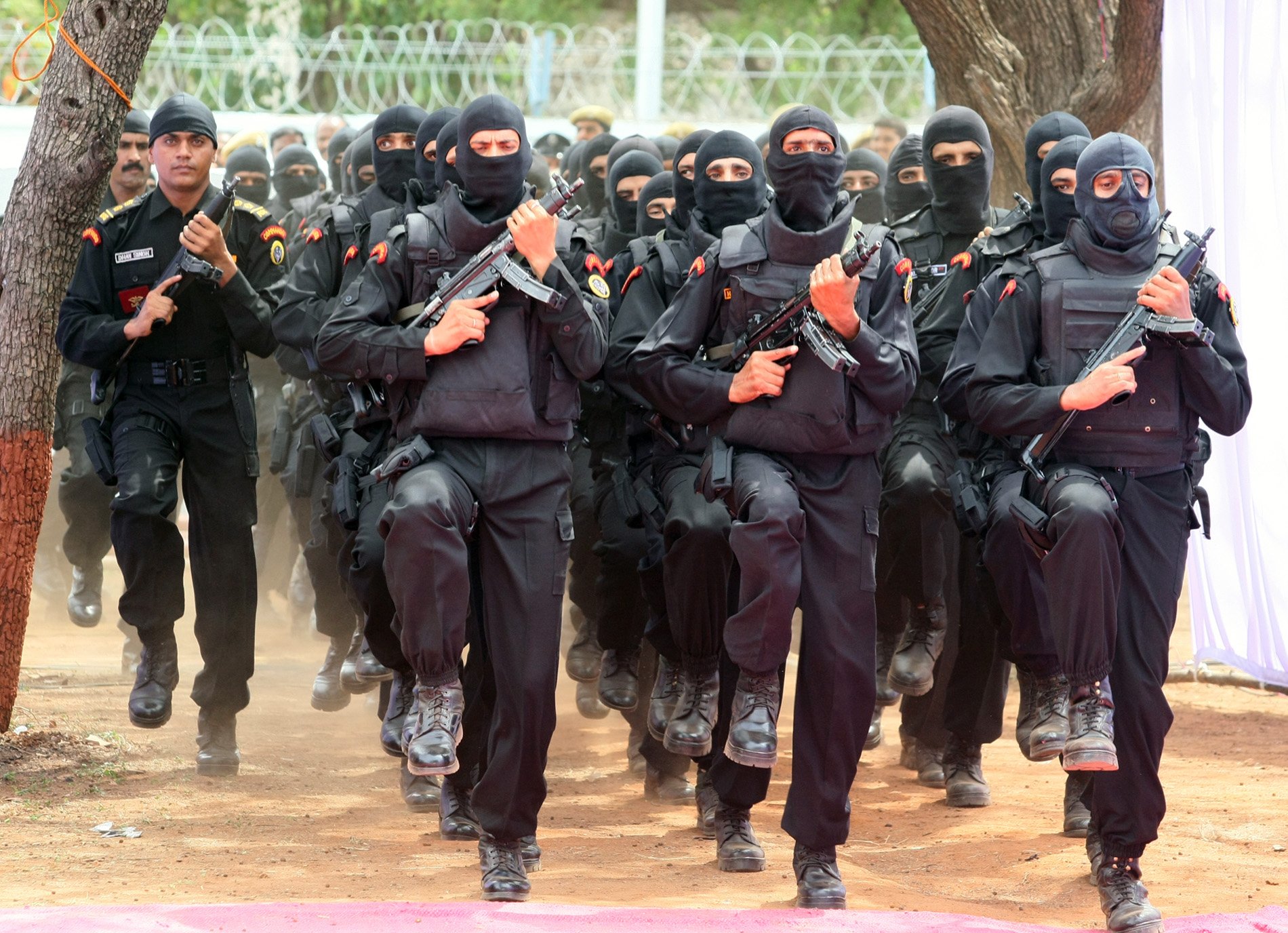 A National Security Guard (NSG) commando stands guard in front of armored  vehicle Sherpa during a car rally of black cats held as part of  celebrations marking 75 years of India's Independence