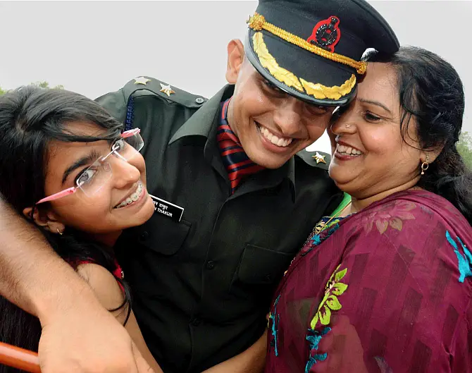Gaya: A cadet is greeted by his family after the passing out parade at Officers Training Academy in Gaya on Saturday. PTI Photo (PTI6_13_2015_000022B) *** Local Caption ***