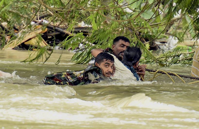 Indian army soldiers rescue a man from flood waters in Chennai, India, Thursday, Dec. 3, 2015. The heaviest rainfall in more than 100 years has devastated swathes of the southern Indian state of Tamil Nadu, with thousands forced to leave their submerged homes and schools, offices and a regional airport shut for a second day Thursday.( R Senthil Kumar / Press Trust of India via AP)