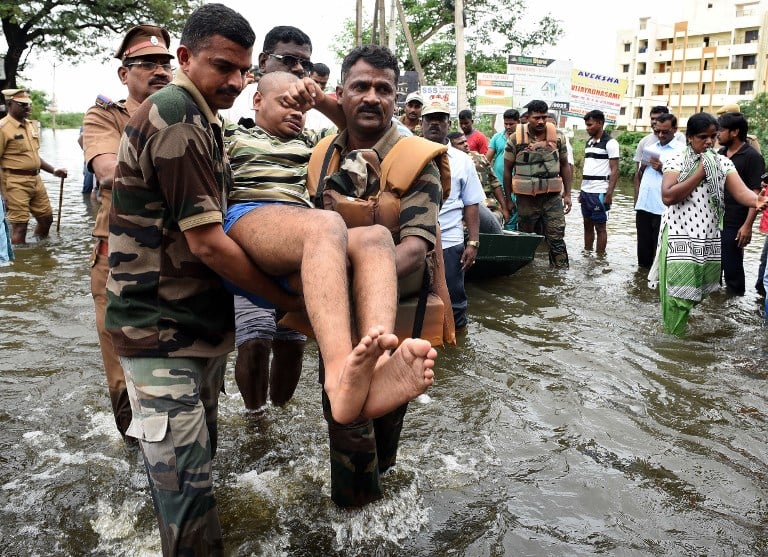 Indian Army personnel rescue flood-affected people during their relief operations in rain-hit areas on the outskirts of Chennai on November 17, 2015.   India has deployed the army and air force to rescue flood-hit residents in the southern state of Tamil Nadu, where at least 71 people have died in around a week of torrential rains.  AFP PHOTO  / AFP / STR